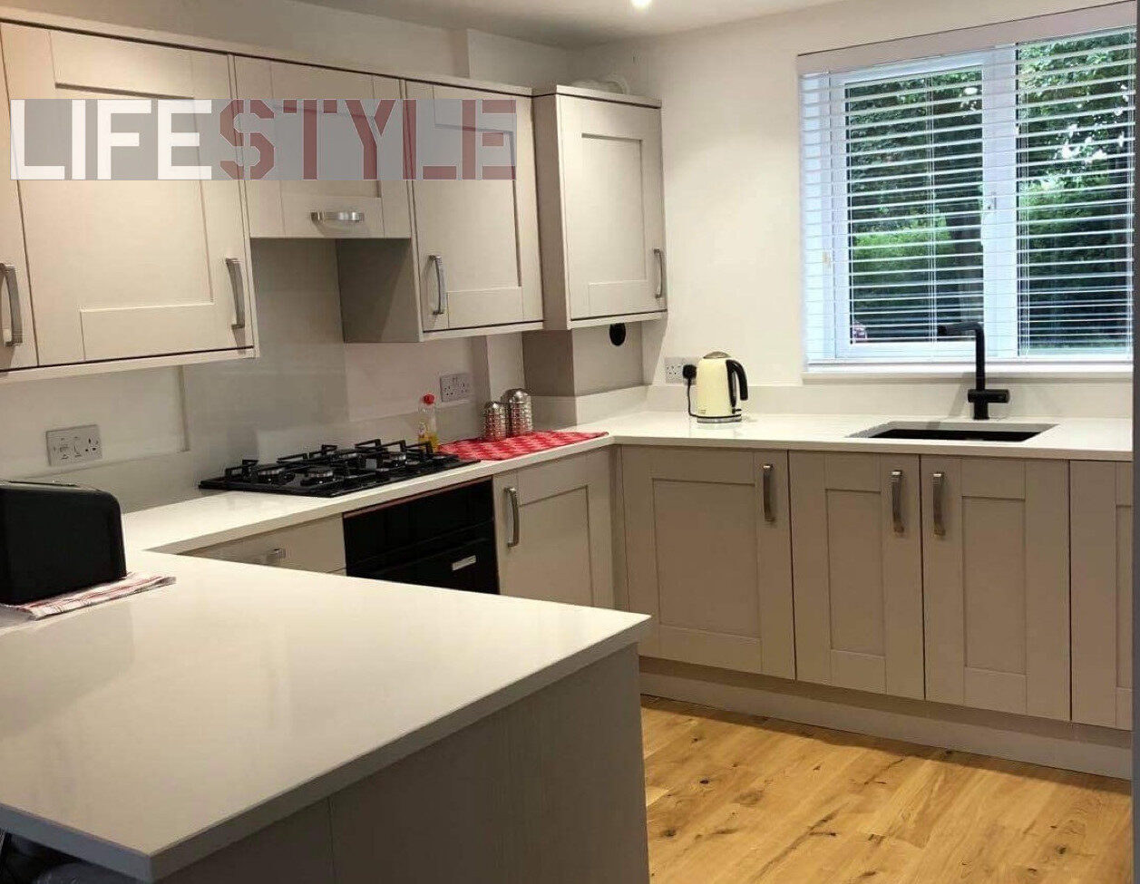 a kitchen with white cabinets and a wood floor