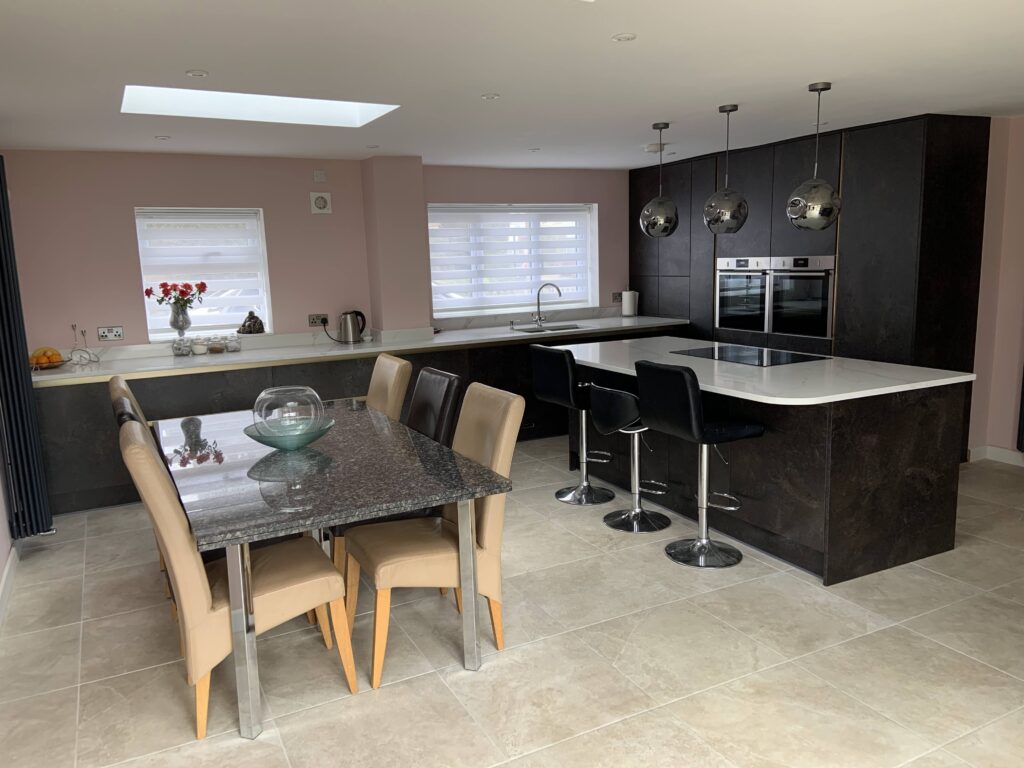 Contemporary Stone Effect Kitchen with Handle-less Doors and Quartz Worktops - Complemented by Pink Walls